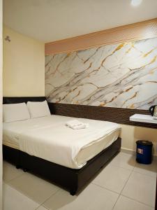 a bed in a room with a marble wall at 28 Gred Hotel in Bukit Mertajam