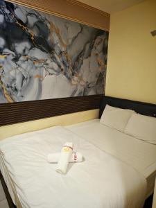 a bed with a rolled up towel on top of it at 28 Gred Hotel in Bukit Mertajam