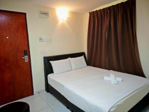 a bed with a stuffed animal sitting on top of it at 28 Gred Hotel in Bukit Mertajam +9 photos