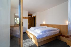 a bedroom with a bed and a glass door at Bormiohomes - Case SteLu in Bormio