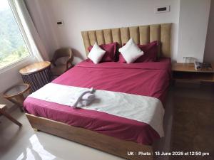 a bedroom with a bed with a stuffed animal on it at The Great Hill View Hotel in Phata