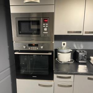 a kitchen with a microwave and a slow cooker at Maison Jehan-Séré in Tarascon-sur-Ariège +14 photos