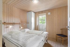 a bedroom with a large white bed with a window at FY166-Middelfart-Skrillinge-Strand-100 in Middelfart
