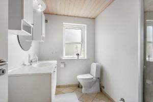 a bathroom with a toilet and a sink and a window at FY166-Middelfart-Skrillinge-Strand-100 in Middelfart +17 photos