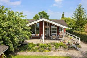 a small house with a wooden porch and a deck at FY166-Middelfart-Skrillinge-Strand-100 in Middelfart