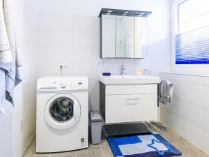 a white bathroom with a washing machine and a sink at Apart Peter in Seefeld in Tirol