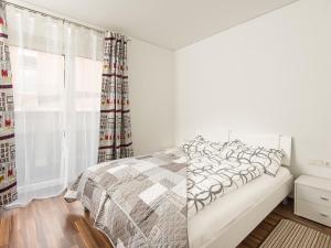 a white bedroom with a bed and a window at Apart Peter in Seefeld in Tirol