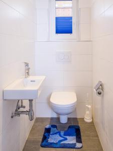 a white bathroom with a toilet and a sink at Apart Peter in Seefeld in Tirol +2 photos