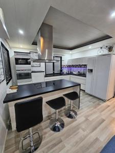 a kitchen with a black counter and two bar stools at House for 4 person near Meyer Turku in Turku