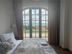 a bedroom with a bed and a large window at Farma HUGÁNIKOVO - families, pets & spa relaxation in Brezno +31 photos