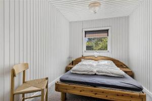a bedroom with a wooden bed with a window at C11306-Tarm-Hjortevej-10 in Tarm
