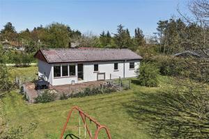 a small white house in a field with a playground at C11306-Tarm-Hjortevej-10 in Tarm +22 photos
