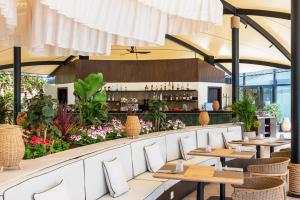 a restaurant with white chairs and tables and flowers at Senator Banus Adults Only Recommended in Estepona