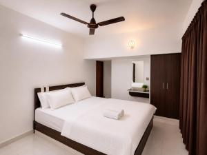 a bedroom with a bed with a ceiling fan at Chooravelil Villa, Adimali - Family Stay Near Munnar in Anniyartholu