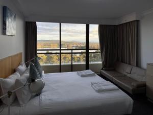 a hotel room with a bed and a large window at Lakefront Panorama – Classic in Canberra +26 photos