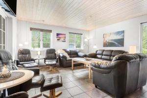 a living room with leather furniture and a table at 945-Frederiksvaerk-Soltoften-3 in Frederiksværk