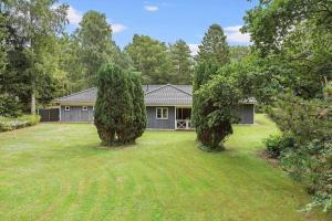 a house with two trees in front of a yard at 945-Frederiksvaerk-Soltoften-3 in Frederiksværk