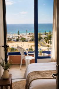 a bedroom with a bed and a view of the beach at La coline vue sur mer Uniquement les familles in Oualidia