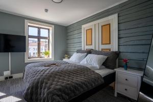 ein Schlafzimmer mit einem großen Bett und einem Fenster in der Unterkunft Bakerigården in Lillesand