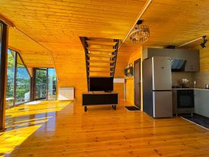a kitchen with wooden floors and a kitchen with a refrigerator at Alamabari Inn in Kobuleti