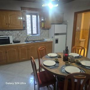 a kitchen with a wooden table with chairs and a dining room at The Relic in Olympos