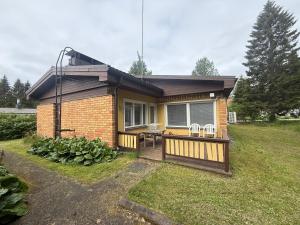 a small house with a porch with a table and chairs at Dream Big House Tervaharju in Kemi