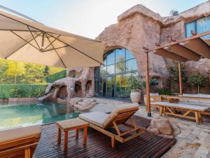 a patio with an umbrella and a pool at Arborea Hotel in Trabzon