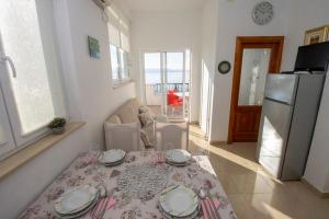 a small kitchen with a table and a refrigerator at Apartmani Jasna in Omiš