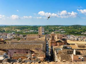 a bird flying over a city with buildings at Panorama Suites Noto - Adults Only in Noto