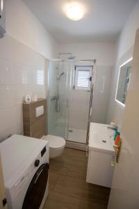a bathroom with a shower and a toilet and a sink at Apartmani Jasna in Omiš +26 photos
