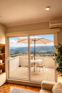 a balcony with a table and an umbrella at Casa do Alto Vila Caiz in Amarante