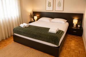 a bedroom with a large bed with towels on it at Casa do Alto Vila Caiz in Amarante