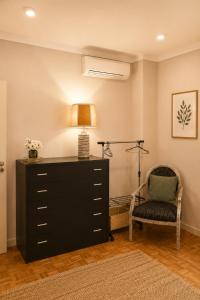 a bedroom with a dresser and a lamp and a chair at Casa do Alto Vila Caiz in Amarante