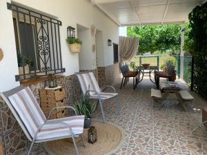 a patio with chairs and a table and a table at Casa Enric , con zona infantil, piscina y parking privado in Deltebre