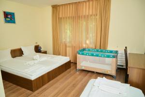 ein Schlafzimmer mit zwei Betten und einem Babybett in der Unterkunft Family Hotel Fedora in Ribarica