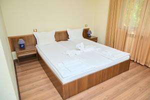 ein Schlafzimmer mit einem großen Bett mit einer Schleife darauf in der Unterkunft Family Hotel Fedora in Ribarica