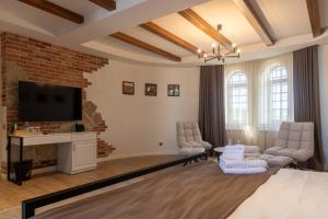 a living room with a tv and a brick wall at Hotel Chateau Cojusna in Cojuşna