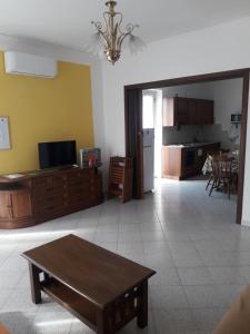 a living room with a table and a kitchen at Doroteafarm, dove saltiamo sull'amore e i sogni in Scalea