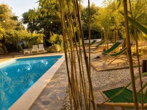 a swimming pool with lounge chairs and a resort at Casa Rico Frade Garden in São Pedro do Corval