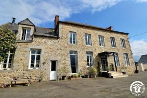 an old stone building with a bench in front of it at Le rok in Billé