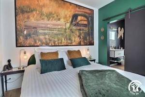 a bedroom with a bed with a painting on the wall at Le rok in Billé