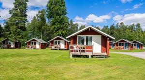 a row of cottages in a field of grass at Norbergs Camping in Norberg +12 photos