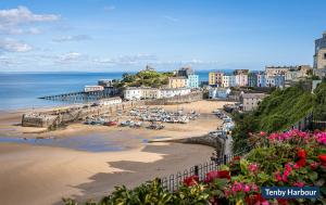 a view of a beach with buildings and a pier at Hafod in Tenby