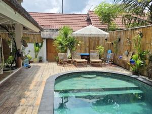 a swimming pool in a backyard with a wooden fence at Villa Asmara Gili Air in Gili Islands