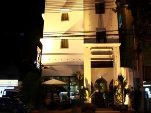 a white building with a lit up tower at night at JamPark City in Bangkok