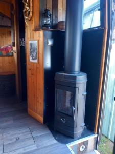 a wood stove in a room with a door at Campertruck Off-Grid in Hénon