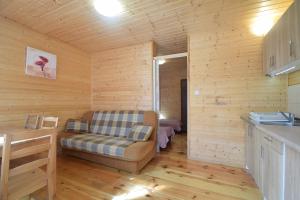 a living room with a couch in a wooden cabin at Domek Letniskowy Paweł in Pogorzelica