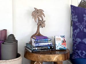 a table with books and a plant on top at Villa Asmara Gili Air in Gili Islands +22 photos