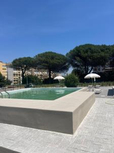 a swimming pool with two umbrellas and two chairs at Residence Niko 5 Pomezia in Pratica di Mare