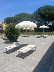 a group of benches with umbrellas in a parking lot at Residence Niko 5 Pomezia in Pratica di Mare +4 photos